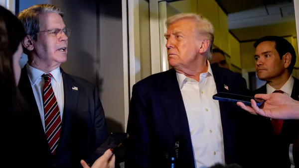 U.S. Treasury Secretary Scott Bessent speaks to reporters next to President Donald Trump and Secretary of State Marco Rubio on Air Force One on Oct. 27, 2025.