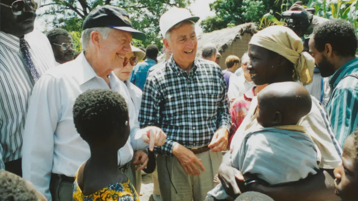 Jimmy Carter and retired Merck CEO Dr. Roy Vagelos meet with people affected by river blindness, 1994.