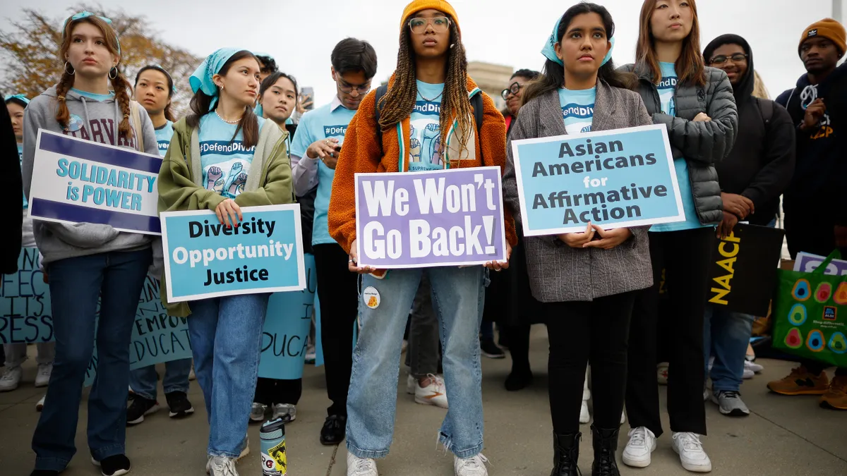 Students stand outside of the U.S. Supreme Court holding placards and signs in favor of affirmative action.