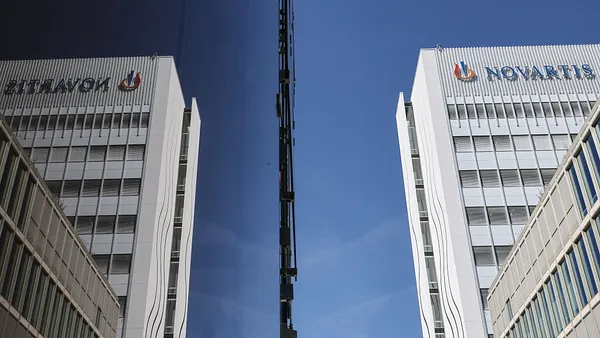 A sign spelling Novartis hangs on the side of a building.