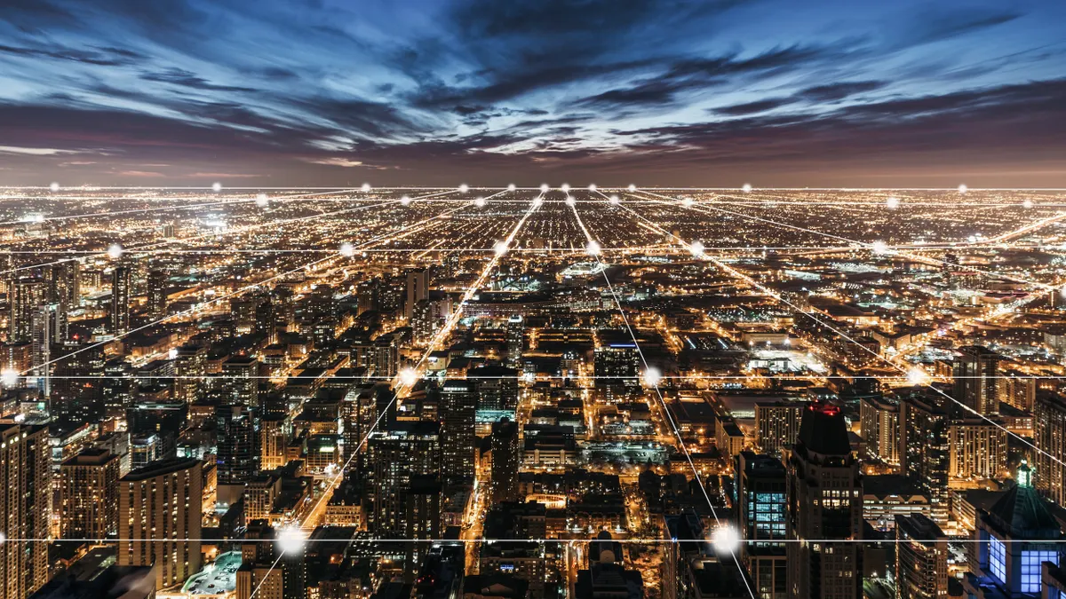 Aerial view of city buildings and lights at night.