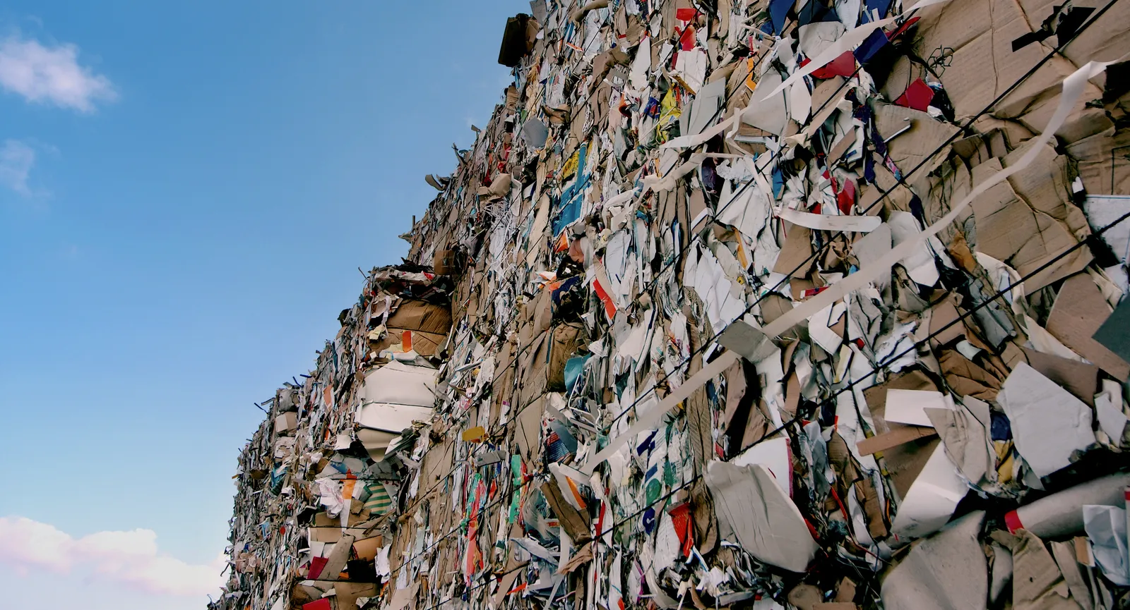 Baled paper in a stack, blue sky above