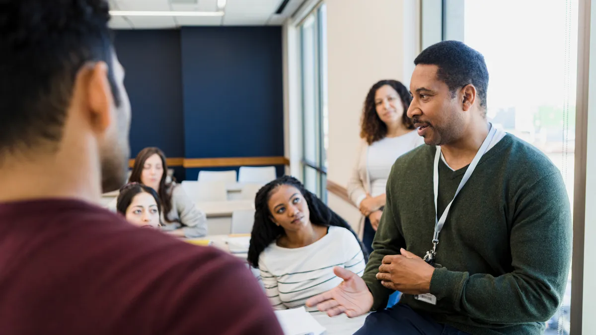 A professor speaks to a lecture hall of college students.