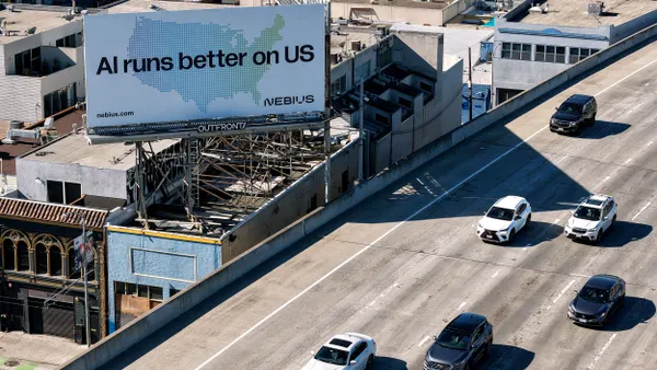 A billboard with the text "AI runs better on us" stands next to a highway.,