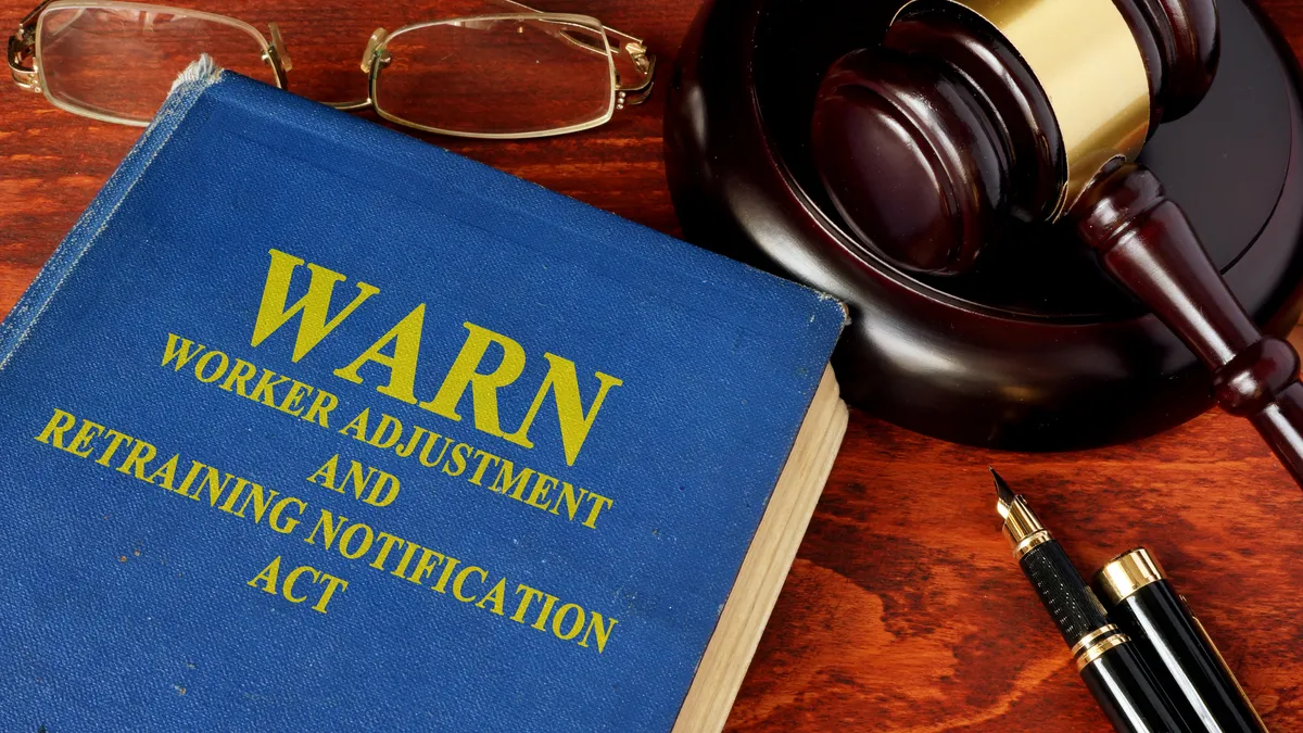 A blue book with yellow "WARN Worker Adjustment and Retraining Notification Act" on the front.