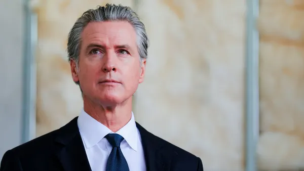 Person in a blue tie and dark suit.