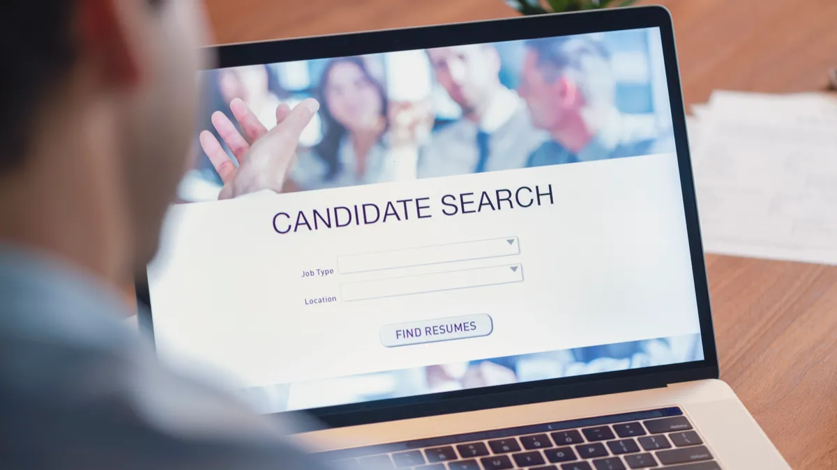 Businessman looking at recruitment website on a laptop computer.