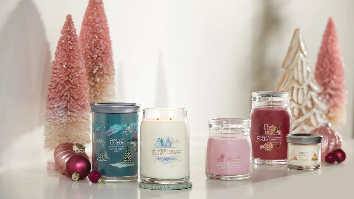 A tableau of five Yankee Candles surrounded by small pink Christmas trees.