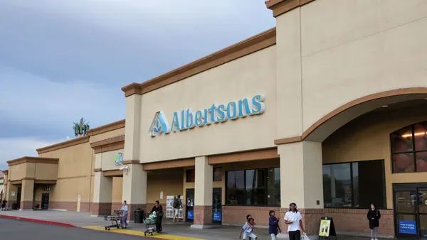 Shoppers walk outside an Albertsons grocery store.