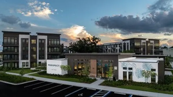 New apartment community with parking lot in the foreground.