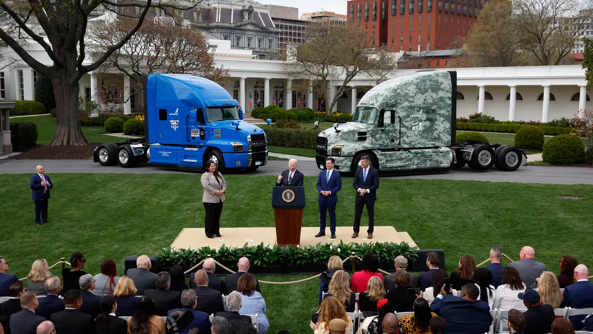 President Joe Biden gives remarks on his Trucking Action Plan on the South Lawn of the White House in front of a pair of trucks.