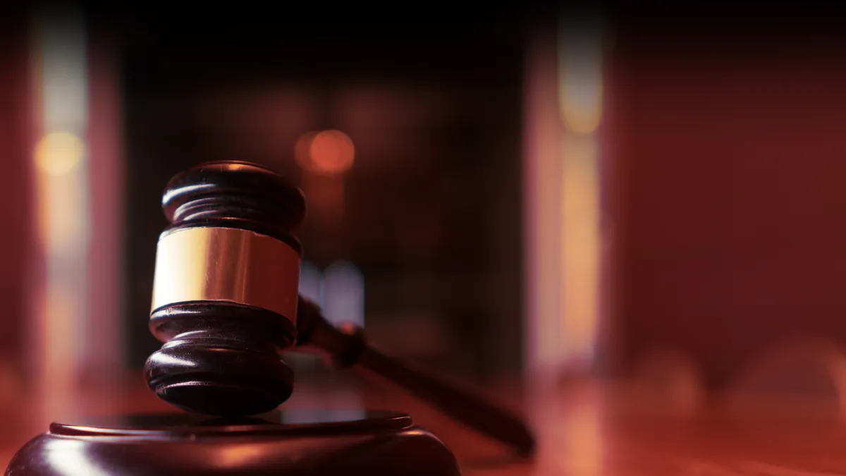 Wooden gavel sits on desk.