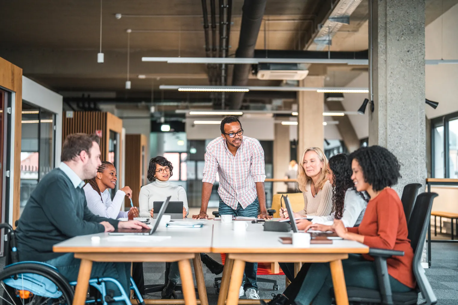 A group of workers sit around an office desk.