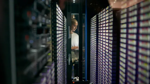 Shot of a young female engineer working in a server room.