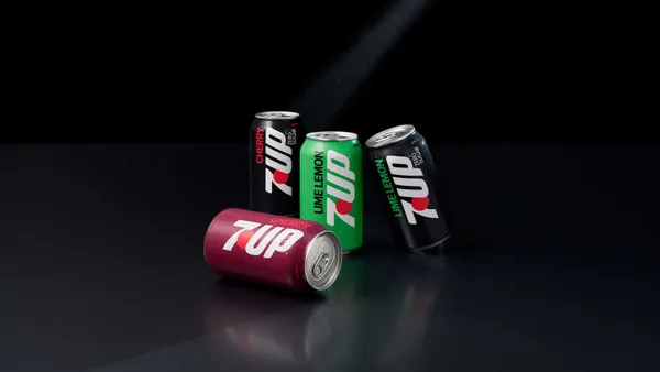 Four cans of the reformulated 7Up are placed together across a black background.