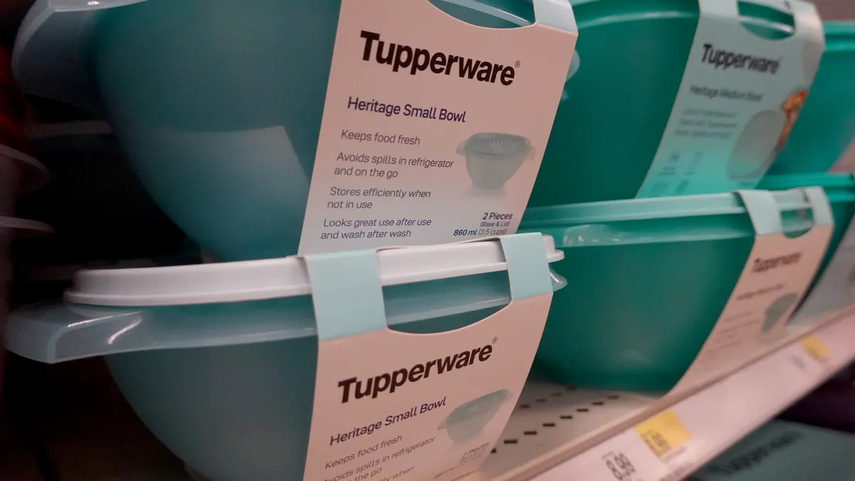 Two stacks of aqua-color Tupperware containers sitting on a store shelf.