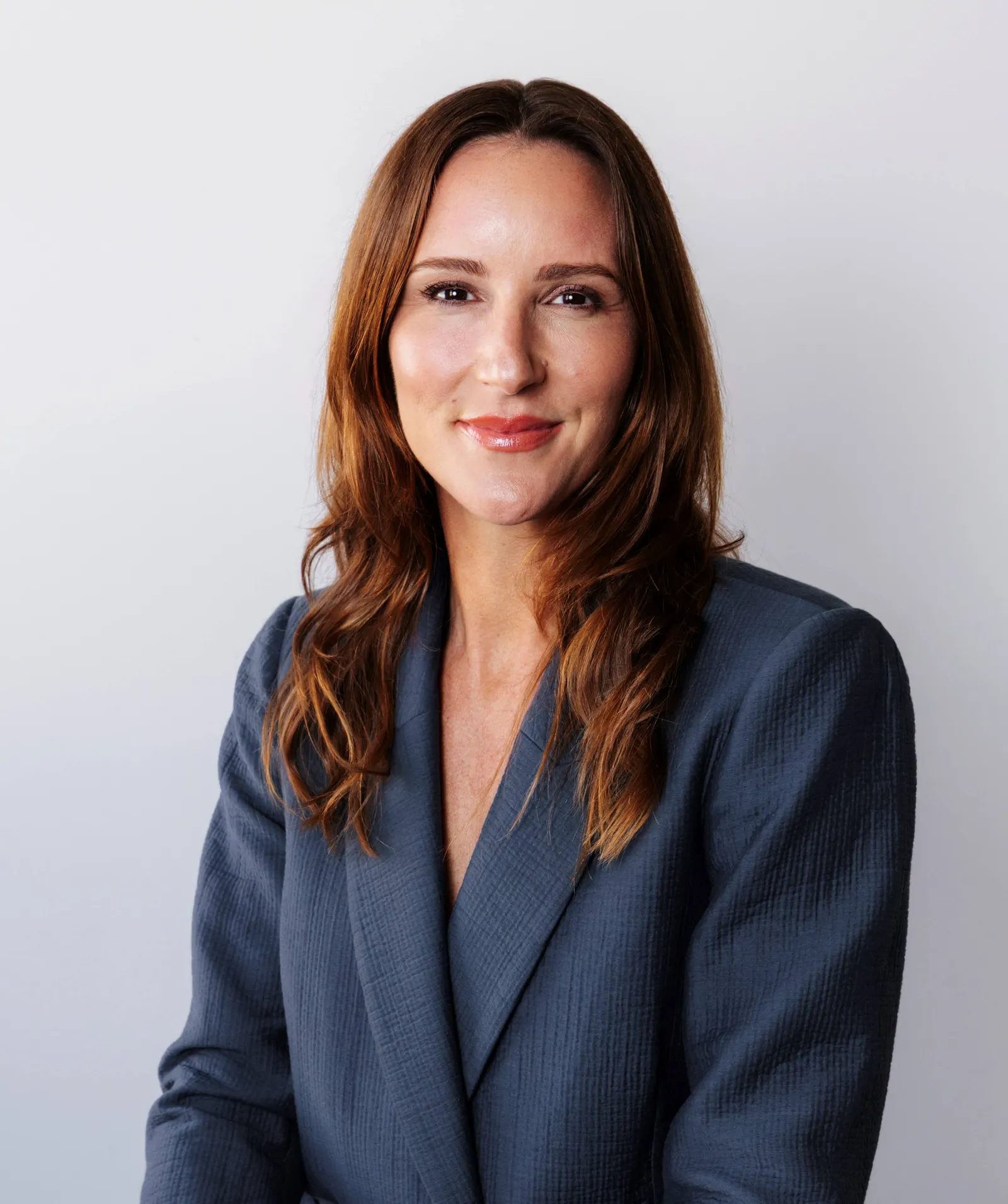 Peloton CMO Megan Imbres wears a slate-gray blazer in a headshot