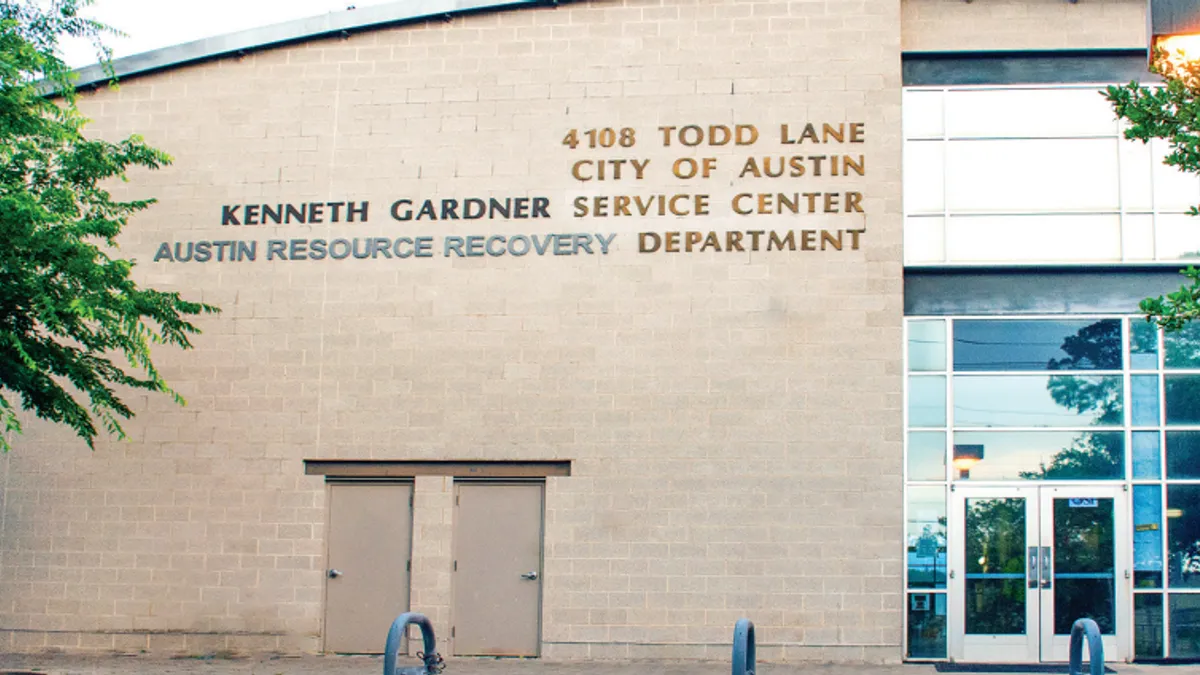 Exterior of a brick and glass building with sign reading "Kenneth Gardner Service Center, Austin Resource Recovery Center."