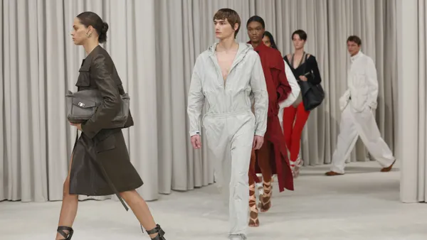 Models walk on a white runway.