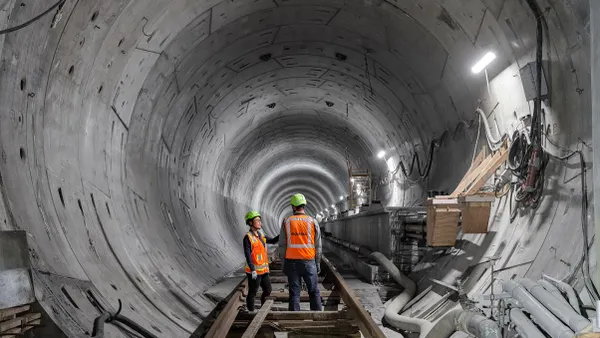 Two construction workers in a tunnel.