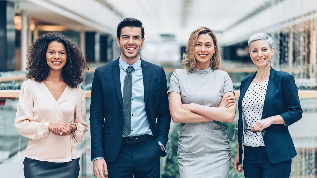 A multiethnic group of legal professionals stand in a lobby