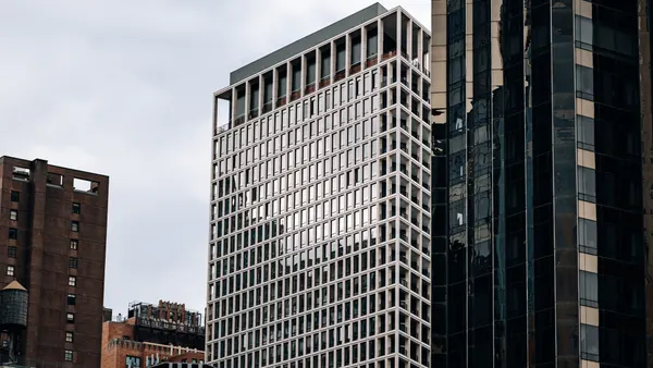 A new york high rise with more buildings in the background and foreground.