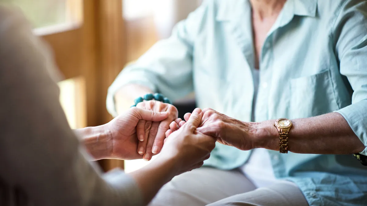 Closeup shot of a young woman holding a senior woman's hands in comfort.