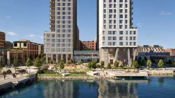 Two apartment towers over a green space.
