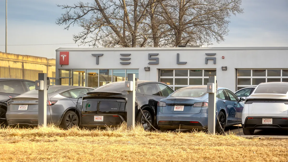 Multiple Tesla electric cars parked at a charging station in front of a Tesla service center building in Calgary, Alberta, on Jan. 21, 2026.