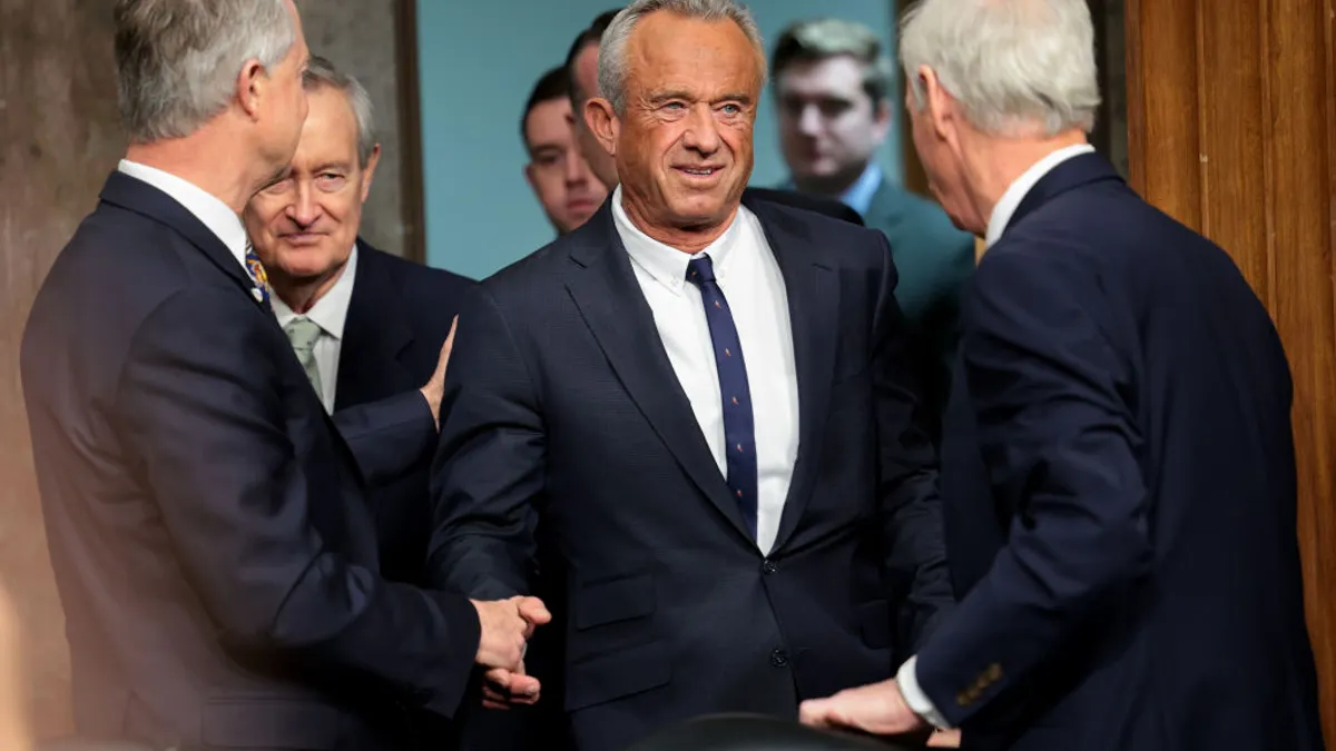 Robert Kennedy shakes hands with members of the senate finance committee