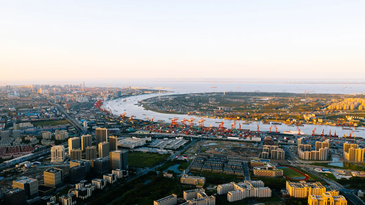 Aerial view of Shanghai skyline. Top view of deep water port with cargo ship and containers in Shanghai.