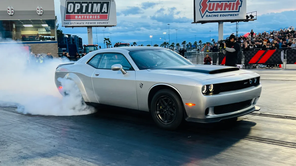 A 2023 Dodge Challenger SRT does a burnout at a racetrack.