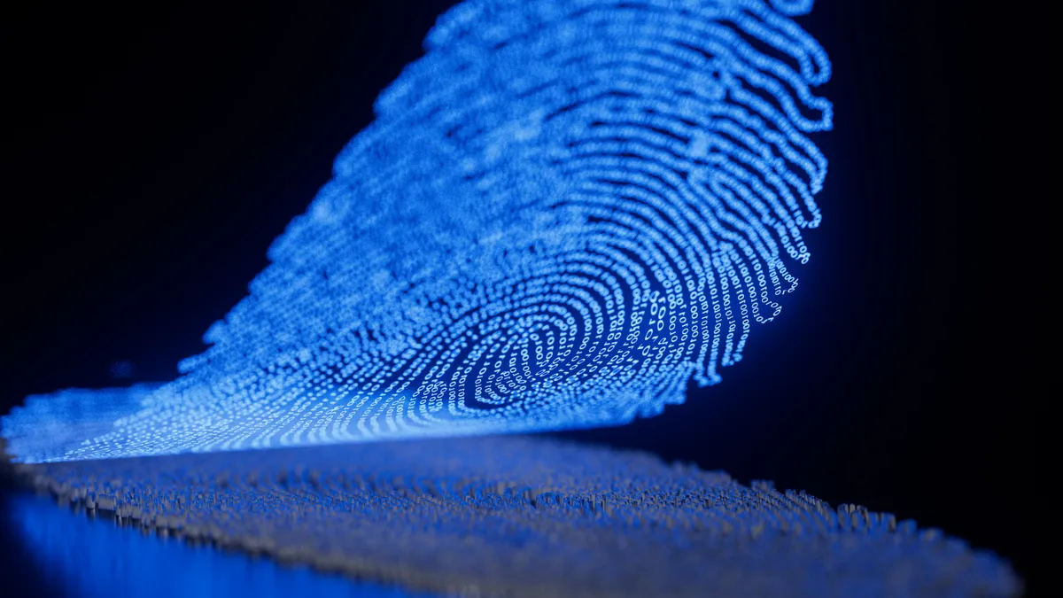 A digital blue fingerprint lifted being lifted off a mirrored surface against a black background. Binary code makes up the fingerprint.