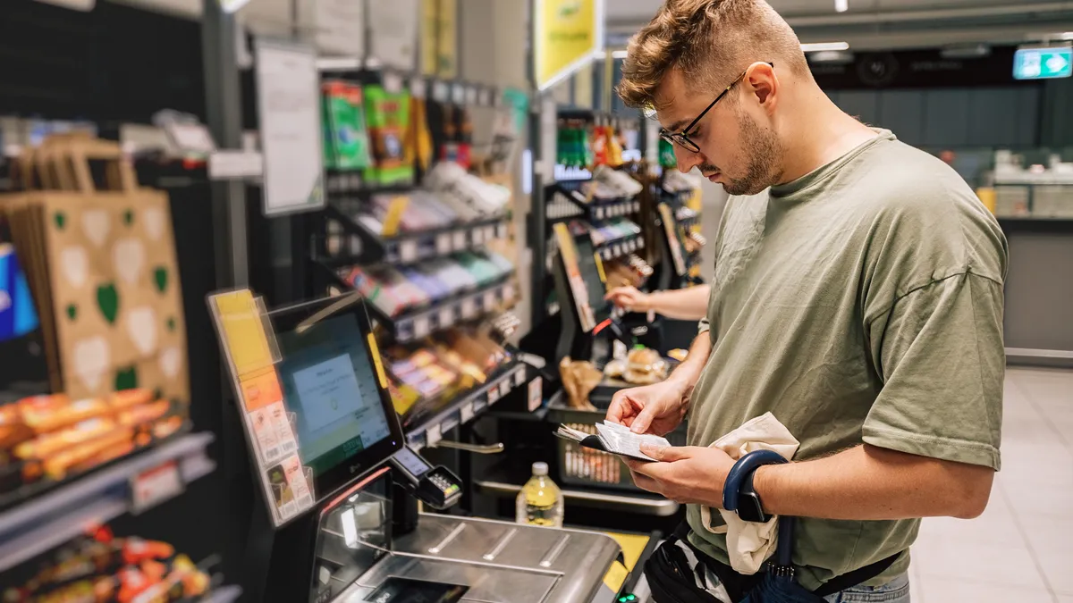 A photo of a Man buying and paying money in the supermarket.