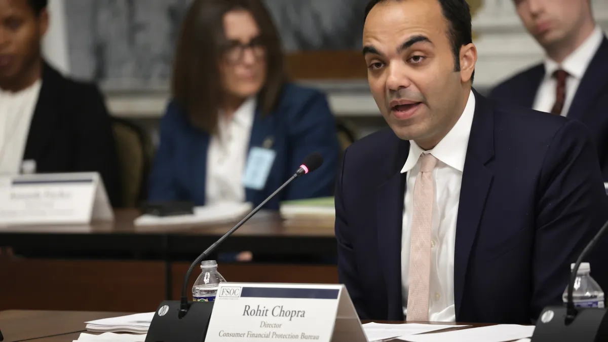 Director of Consumer Financial Protection Bureau Rohit Chopra speaking in front of a desk.