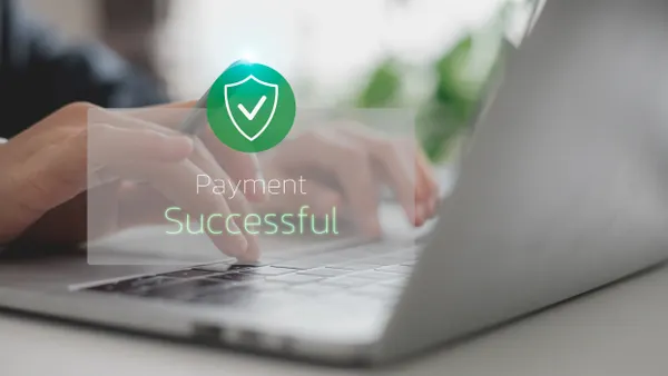 Payment successful icon over a laptop