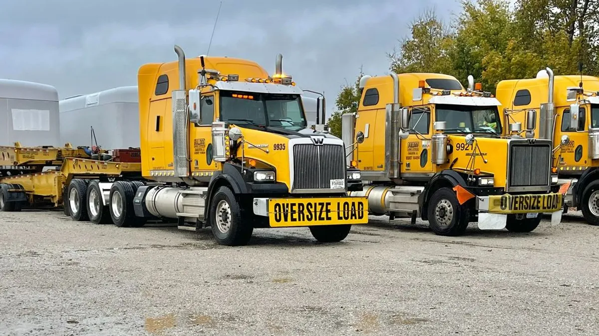 Yellow Bulldog Hiway Express trucks parked in a row with oversized loads.