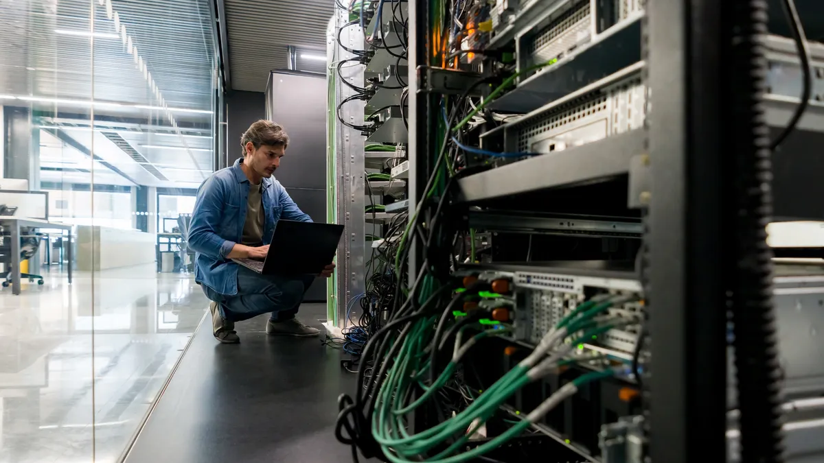 a technician reviews IT equipment in an IT room