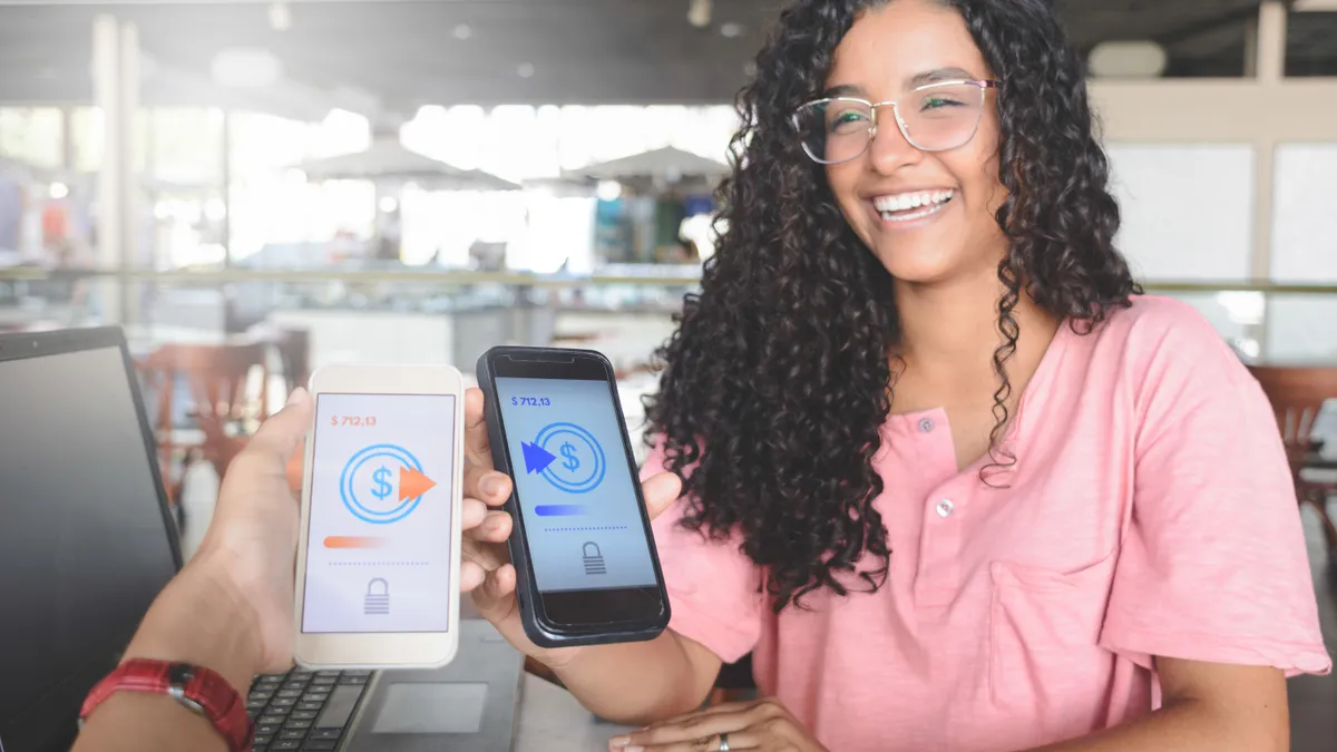 Young women sending money through digital wallet, using wireless technology.