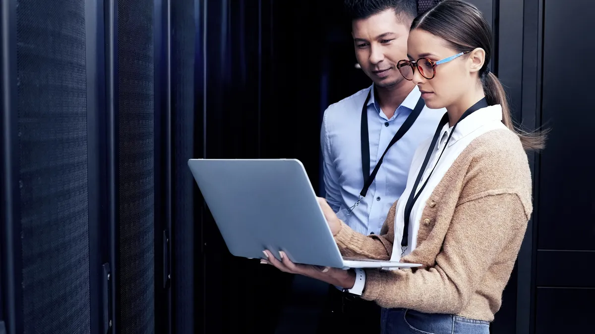 Two technicians working together in a server room.