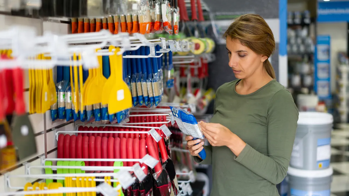 A woman shops for paint brushes in a home improvement store