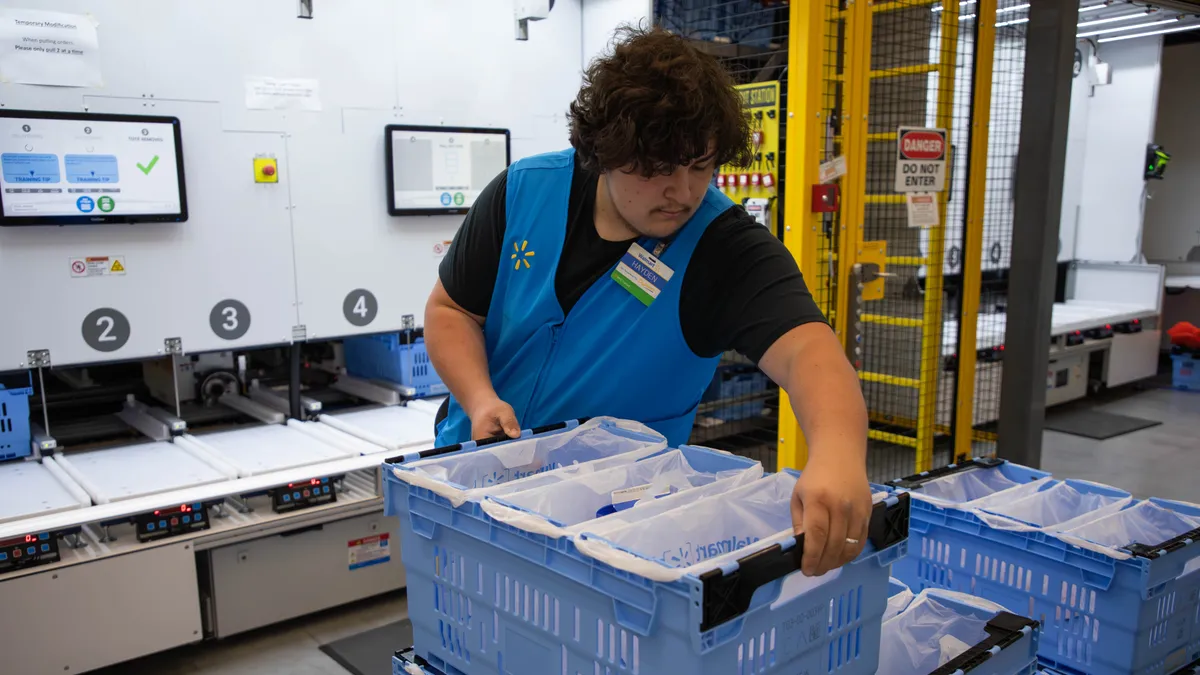 A Walmart employee handles a crate in a market fulfillment center.