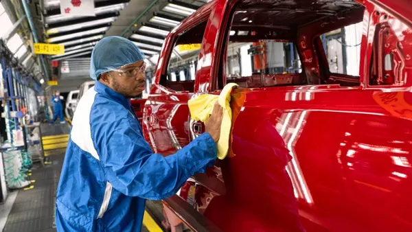 A employee polishes a red painted vehicle at GM's Wentzville Assembly plant in Missouri.