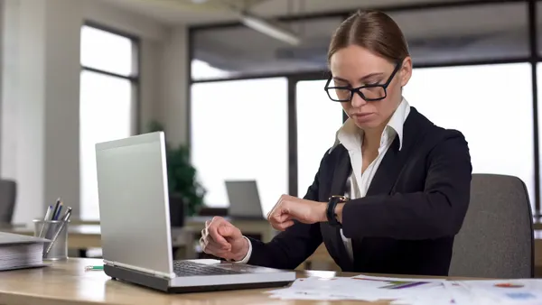 Busy women inside the office looking at her wrist watch