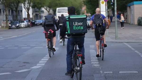 The back of a bike courier with an Uber Eats bag.