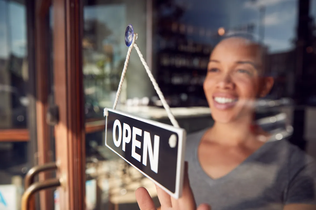 An image of a woman at open sign.