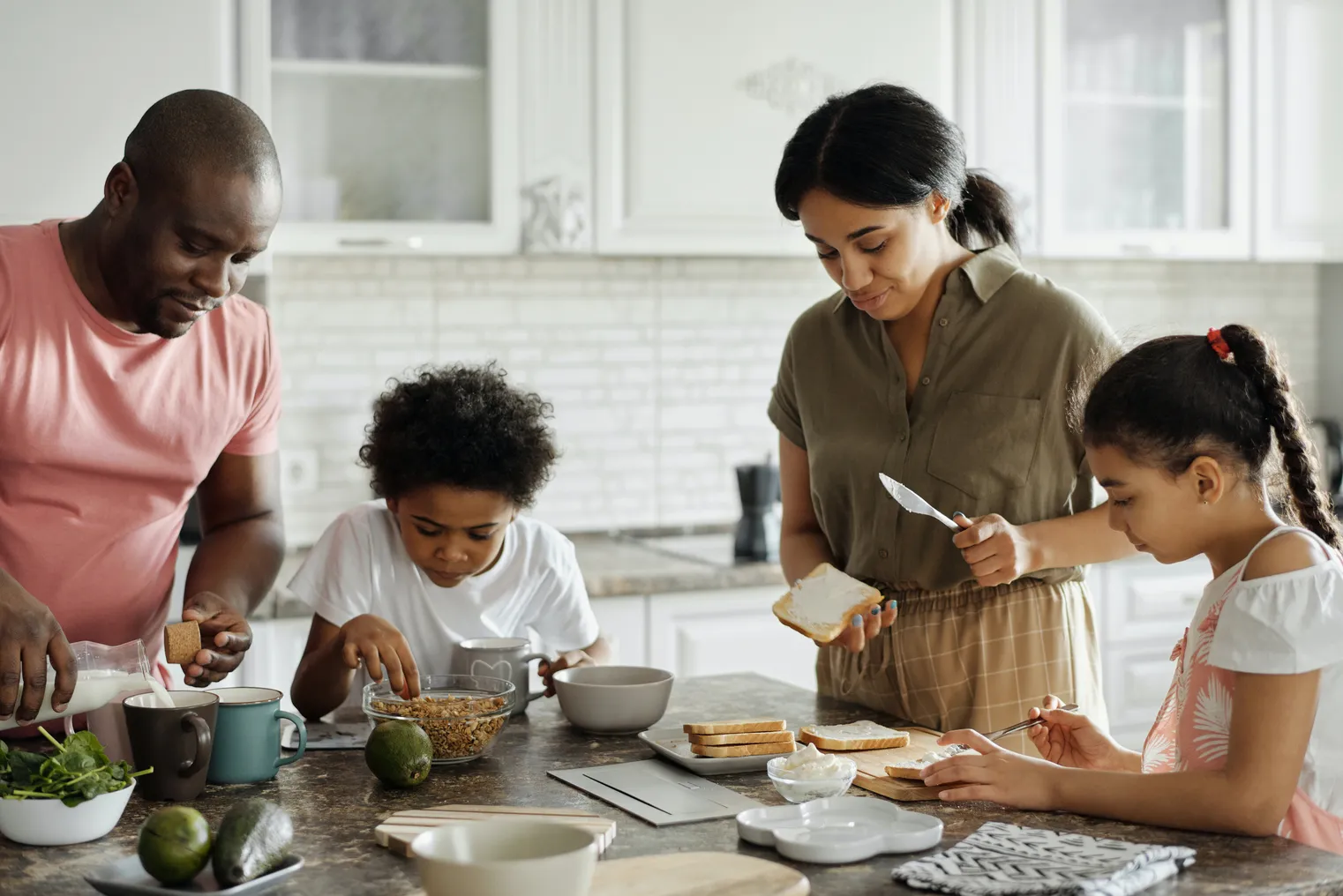 A brown family cooks together in a kitchen