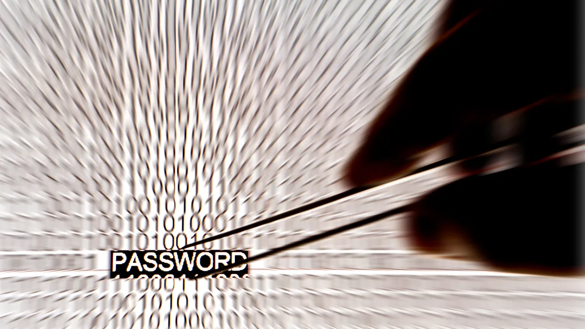 Hand grabbing password out of blurred code.