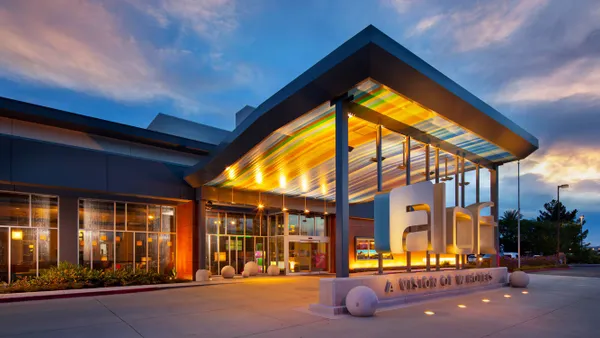 The lobby of a hotel features couches and overhead lamps.