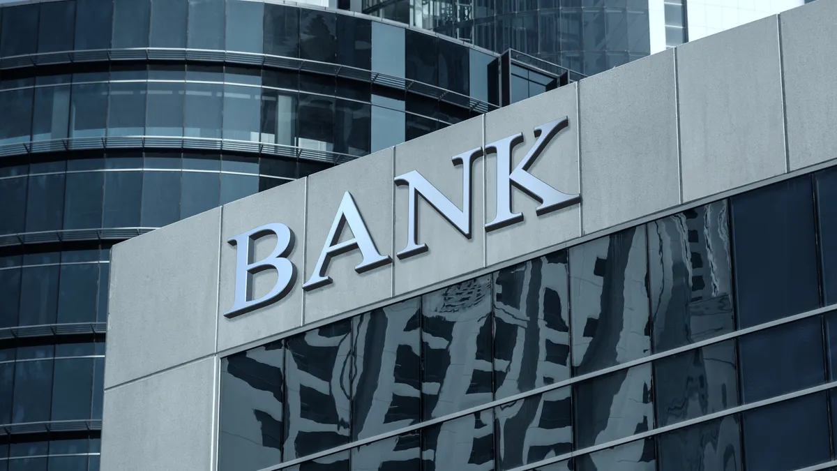 Bank sign on glass wall of business center.